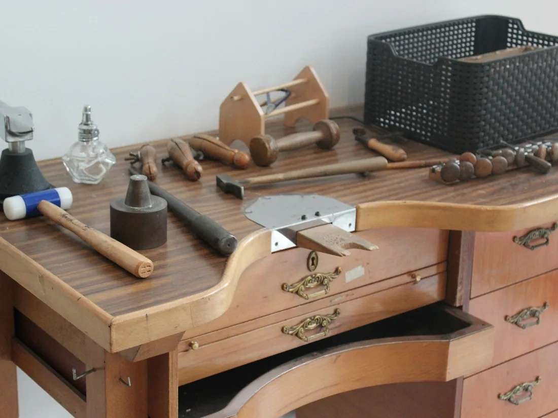 Banco de taller de madera con gubias, formones y herramientas de mano ordenadas sobre la superficie